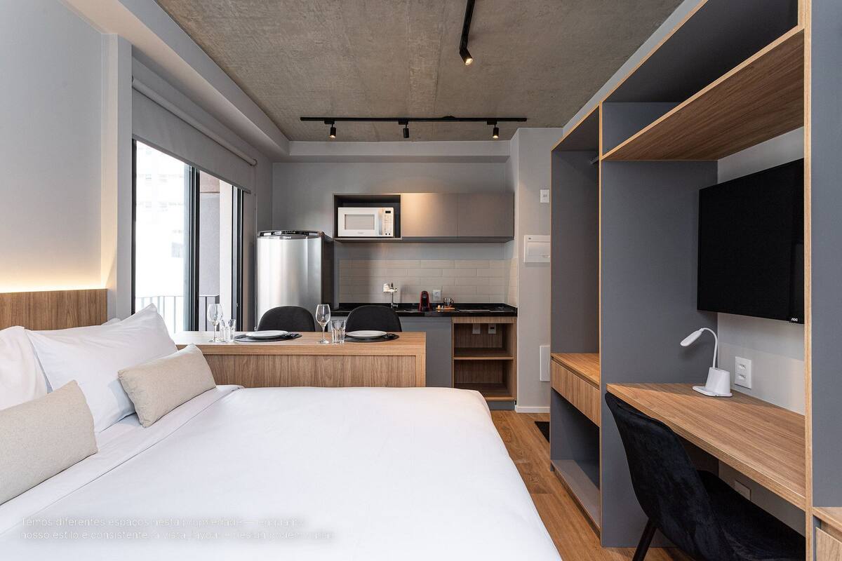 Une chambre d’hôtel équipée d’un lit, d’un bureau, d’une télévision, d’un four à micro-ondes et d’une kitchenette.