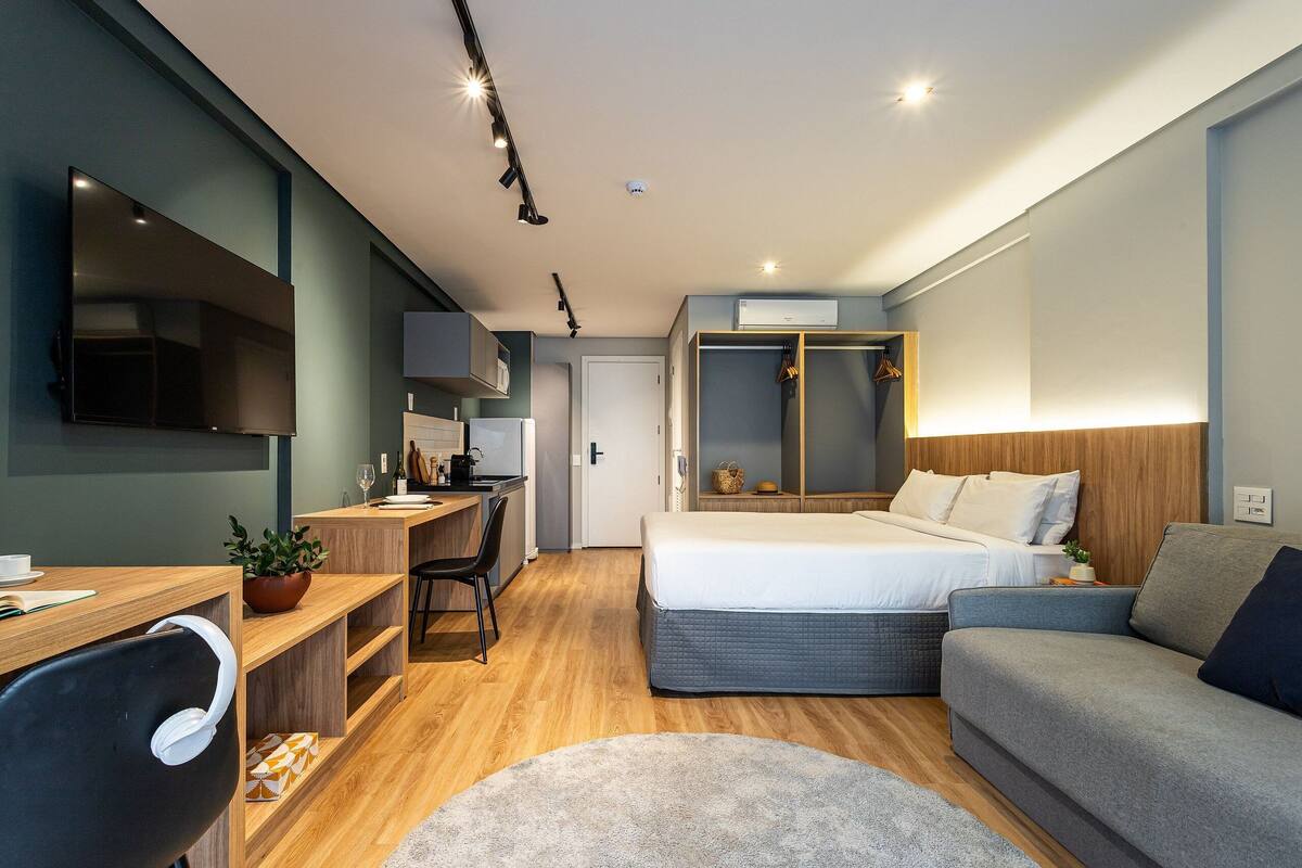 Une chambre d’hôtel moderne équipée d’un lit, d’un canapé, d’un bureau et d’une télévision.