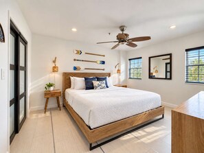 A bedroom with a bed, a ceiling fan, a bedside table with a lamp, and a window with blinds. - Captain's Quarters | Top Floor | Ocean Pointe 4405 (Tavernier)
