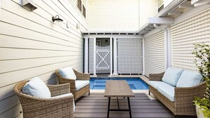 A deck with wicker furniture and a pool. - Cape Henry Full Suite Inn at Old Beach (Virginia Beach)