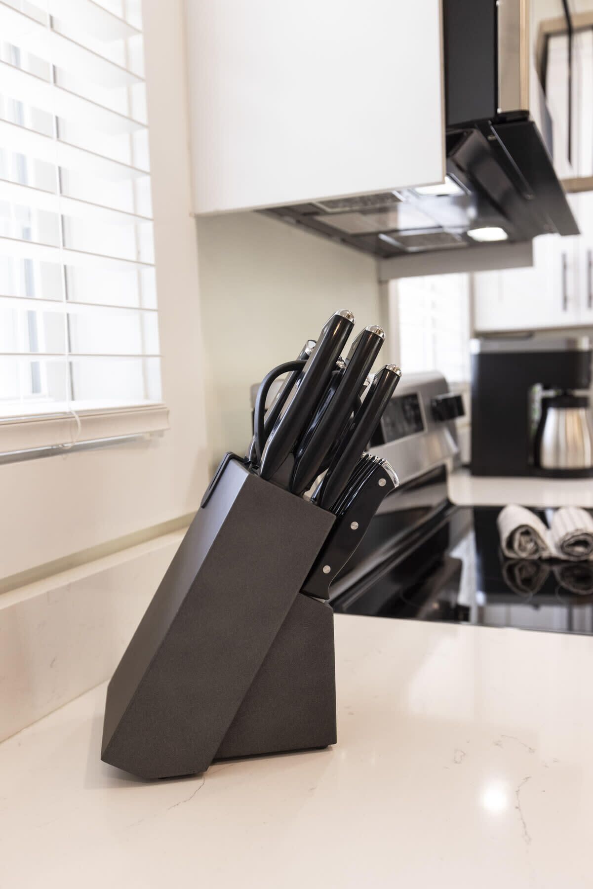 A kitchen with a knife block on the counter.