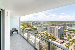 A balcony with a view of a cityscape, including high-rise buildings and a river. - Beachfront Hyde Getaway (Hollywood)