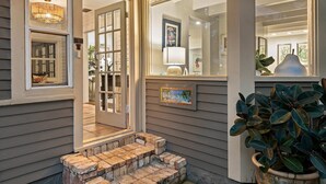 L’entrée d’un hôtel, avec une porte en verre, un panneau d’accueil et une plante en pot.