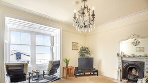 Ein Wohnzimmer mit Kamin, Fernseher und zwei Sesseln.