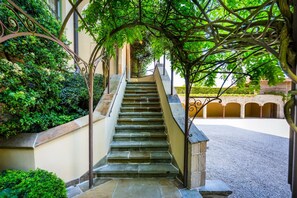 A stone staircase leading to an upper level, surrounded by greenery and a covered area with arches. - LeSable luxury holiday home (Kluisbergen)