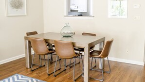 Een eetruimte met een houten tafel, vier lederen stoelen en een glazen vaas als middelpunt.