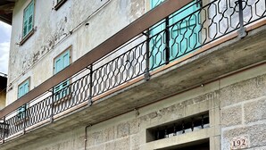 Un bâtiment en pierre avec un banc en bois, une porte et une boîte aux lettres.