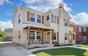Situated in a well-maintained neighborhood, this two-story home features a charming porch area and a grassy front yard.