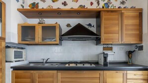 Eine Küche mit Holzschränken, einer Mikrowelle, einem Gasherd und einem Toaster.