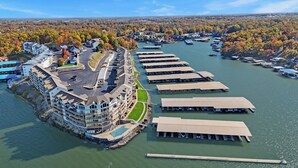 A waterfront hotel with a marina, a parking lot, and a view of the surrounding forest. - Beautiful Main Channel View Cozy Condo in the HEART of Osage Beach! (Osage Beach)