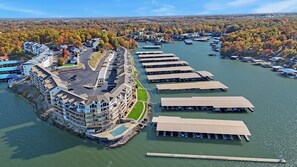 A waterfront hotel with a marina, a parking lot, and a view of the surrounding forest.