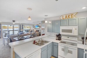 Una cocina moderna con una isla grande, electrodomésticos de acero inoxidable y vistas al lago.