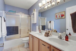 Une salle de bain équipée d’une douche, de toilettes, d’un lavabo et de meubles de rangement.
