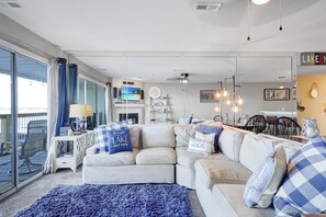 Una sala de estar con sofá, televisión, chimenea y comedor.
