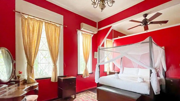 A bedroom with a four-poster bed, a vanity with a mirror, and a red and white color scheme. - Spice House Private Villa with Pool at Mount Edgecombe Boutique Hotel in Grenada (Victoria)