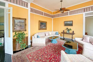 A living room with a sofa, a coffee table, and a ceiling fan. - Spice House Private Villa with Pool at Mount Edgecombe Boutique Hotel in Grenada (Victoria)