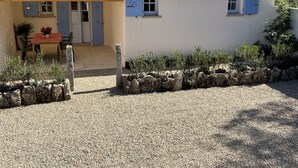 Ett hus med ett tak täckt av takpannor, en inglasad uteplats och en grusuppfart.