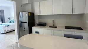 A modern kitchen with white cabinets, a stainless steel refrigerator, and a built-in oven. - Kuyaan 44 Suites (Playa del Carmen)