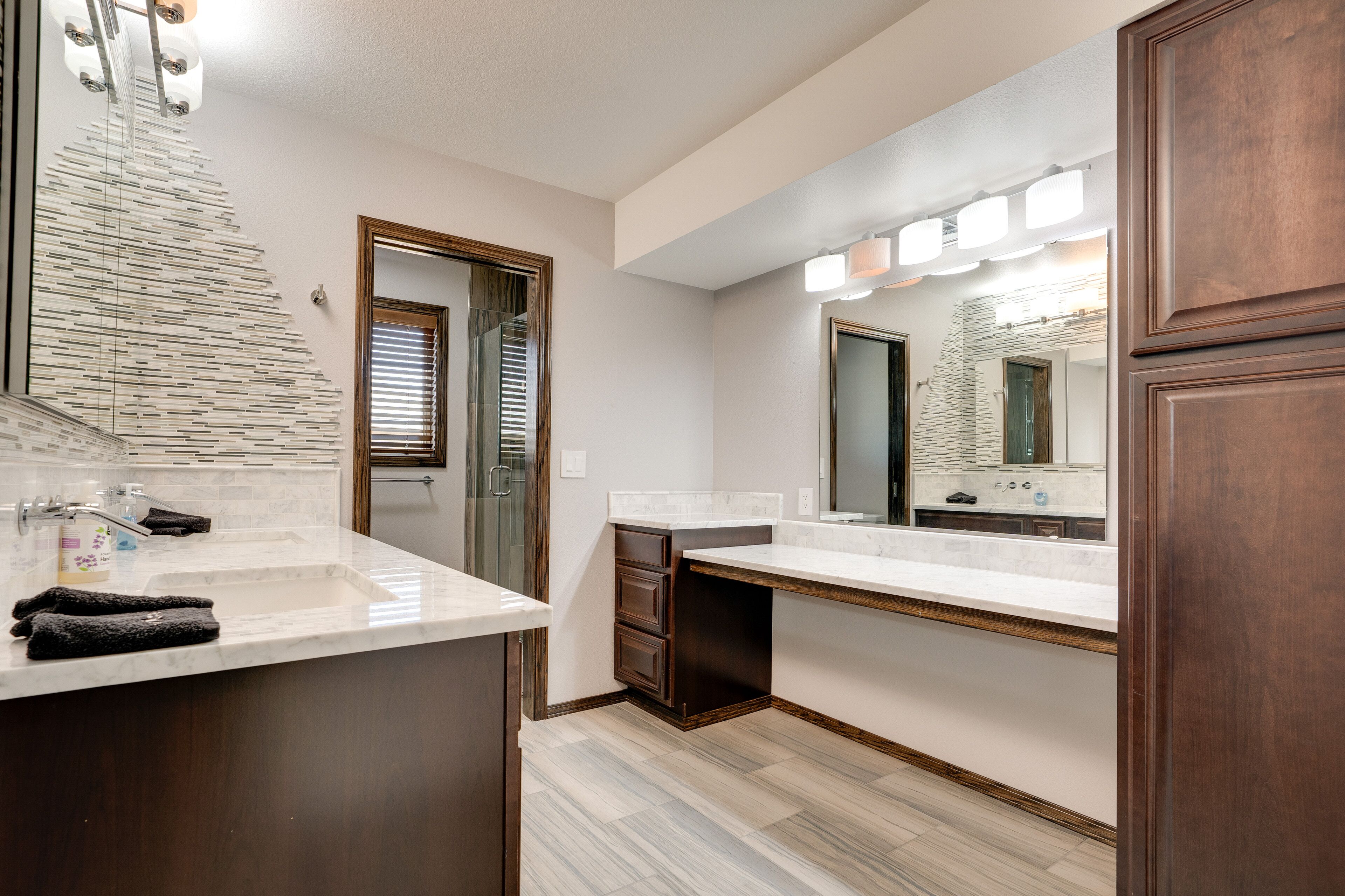 Une salle de bain moderne avec un grand miroir, un lavabo et un meuble-lavabo.