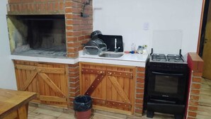 Una cocina con horno de ladrillo, un lavamanos y una estufa a gas.