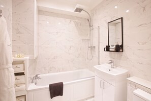 A modern bathroom with a bathtub, a sink, and a shower.