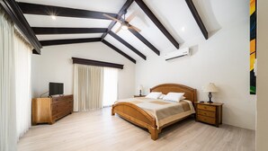 A bedroom with a wooden bed, a nightstand, a dresser, and a ceiling fan. - Freshly Updated 3BR With Pool Walk to the Beach Casa Luz de Luna (Tempate)
