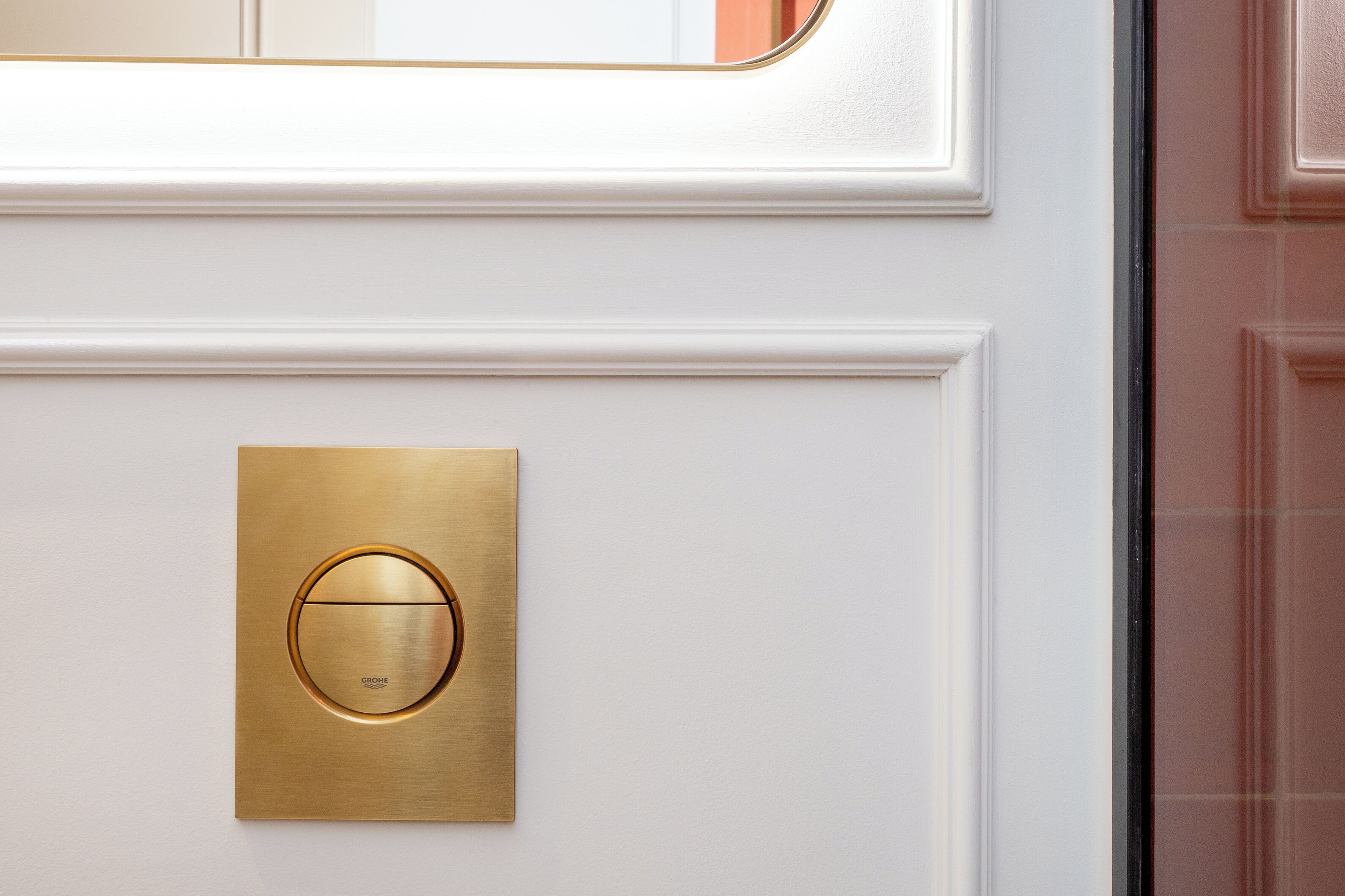 A door with a brass intercom and a glass panel.