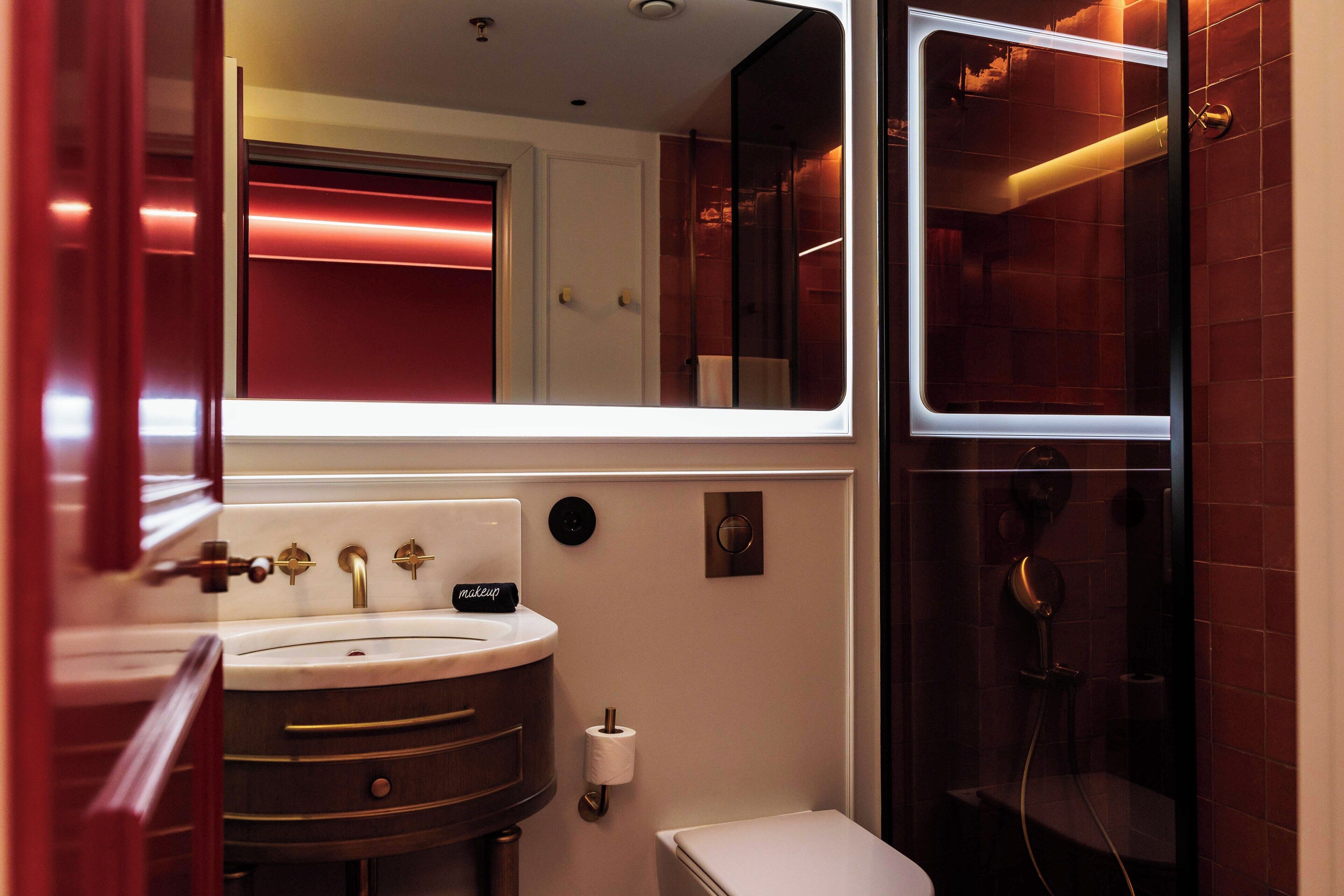 Un baño moderno con lavamanos, inodoro y ducha.