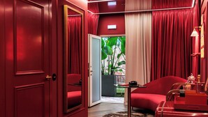 Une pièce décorée dans les tons de rouge, avec un canapé, une petite table et un miroir.