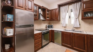 A kitchen with wooden cabinets, a stainless steel refrigerator, a microwave, an oven, and a dishwasher.