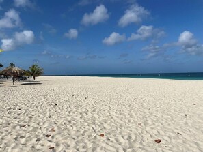 A wide sandy beach with a clear blue sky and a few scattered clouds. - Amazing 2-Bedroom Townhouse near Eagle Beach (Eagle Beach)