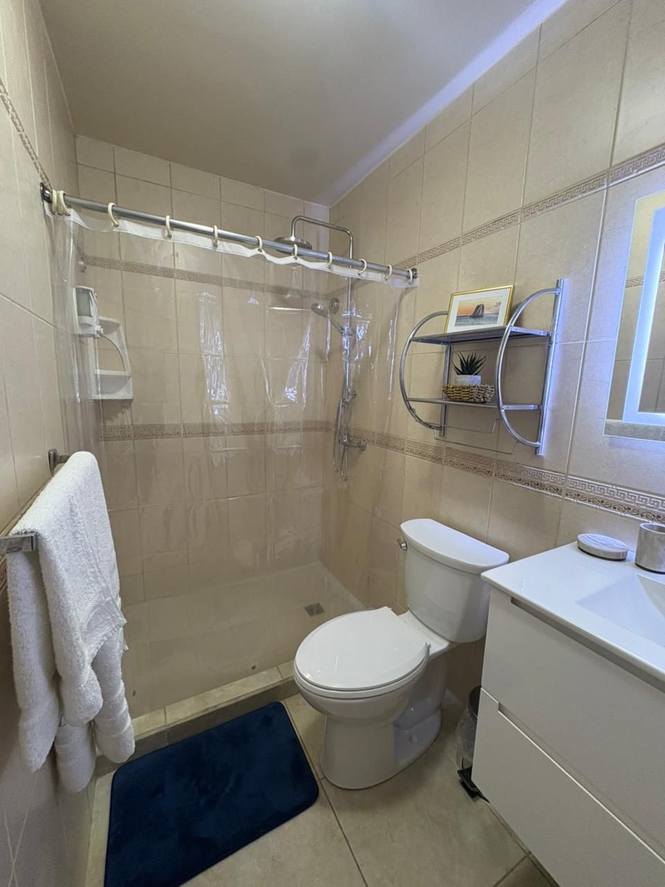 A bathroom with a shower, toilet, and sink.