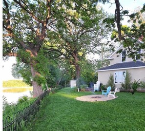 A backyard with a lawn, a fire pit, and outdoor furniture. - 200' of Shoreline for Great Fishing - Park Place on Foot Lake in Willmar MN (Willmar)