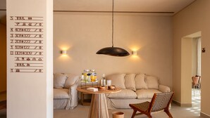 A cozy living room with a sofa, a wooden coffee table, and a hanging light fixture. - Upon Vila Alcochete Hotel (Alcochete)