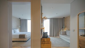 A modern hotel room with a bed, a sofa, a wooden coffee table, and a mirror. - Upon Vila Alcochete Hotel (Alcochete)