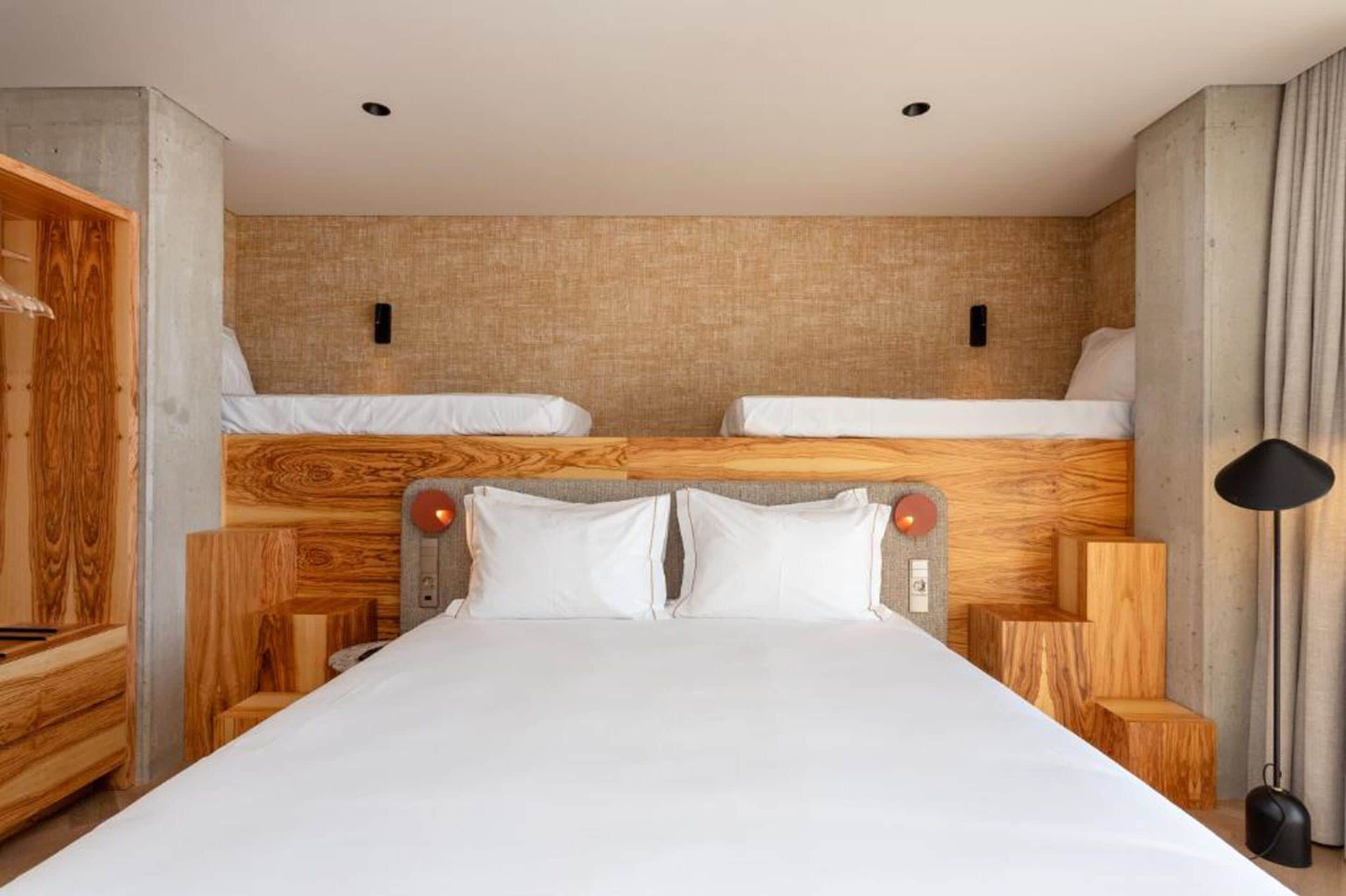 A double bed with a wooden headboard, two bedside tables, and a nightstand.