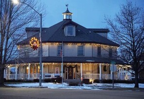 Cozy home with a gabled roof and central chimney, featuring a welcoming front porch and a charming entrance.