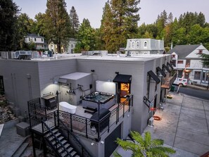 A rooftop with a hot tub, outdoor seating, and a staircase leading to an upper level. - Downtown Gold Mine (Nevada City)