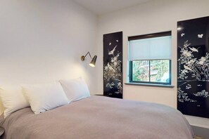 A bedroom with a bed, a window, and wall art. - Downtown Gold Mine (Nevada City)