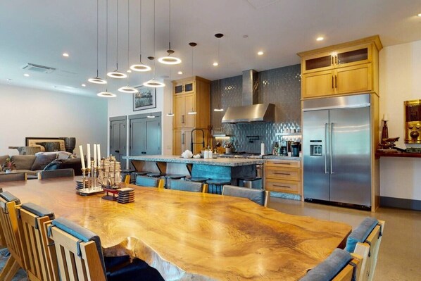 A modern kitchen with a central island, stainless steel appliances, and pendant lighting.