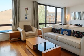 Leilighet – deluxe | Oppholdsområde | En 38-tommers Flatskjerm-TV med Parabol-TV