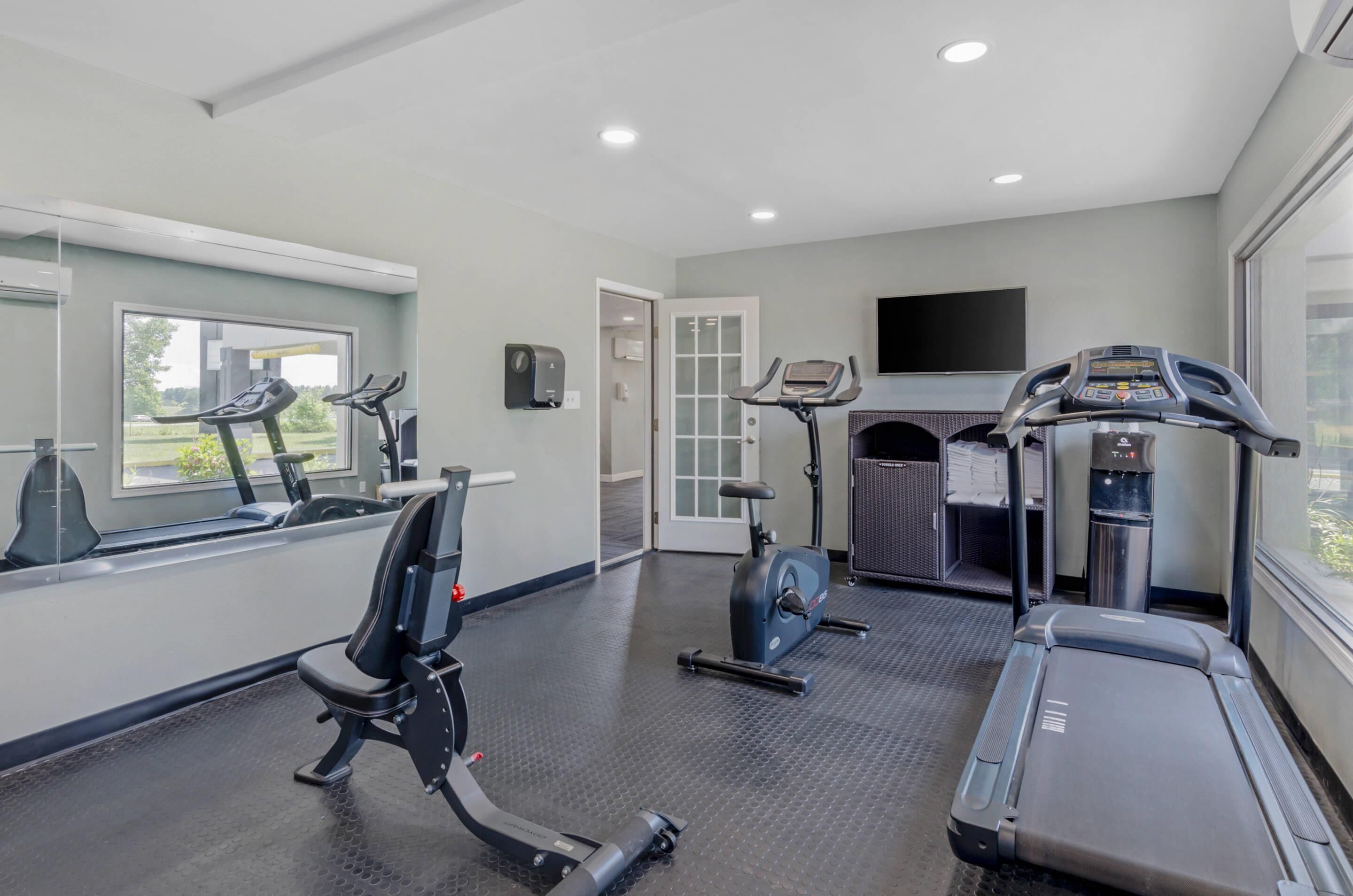 A gym with treadmills, an elliptical, and a stationary bike.
