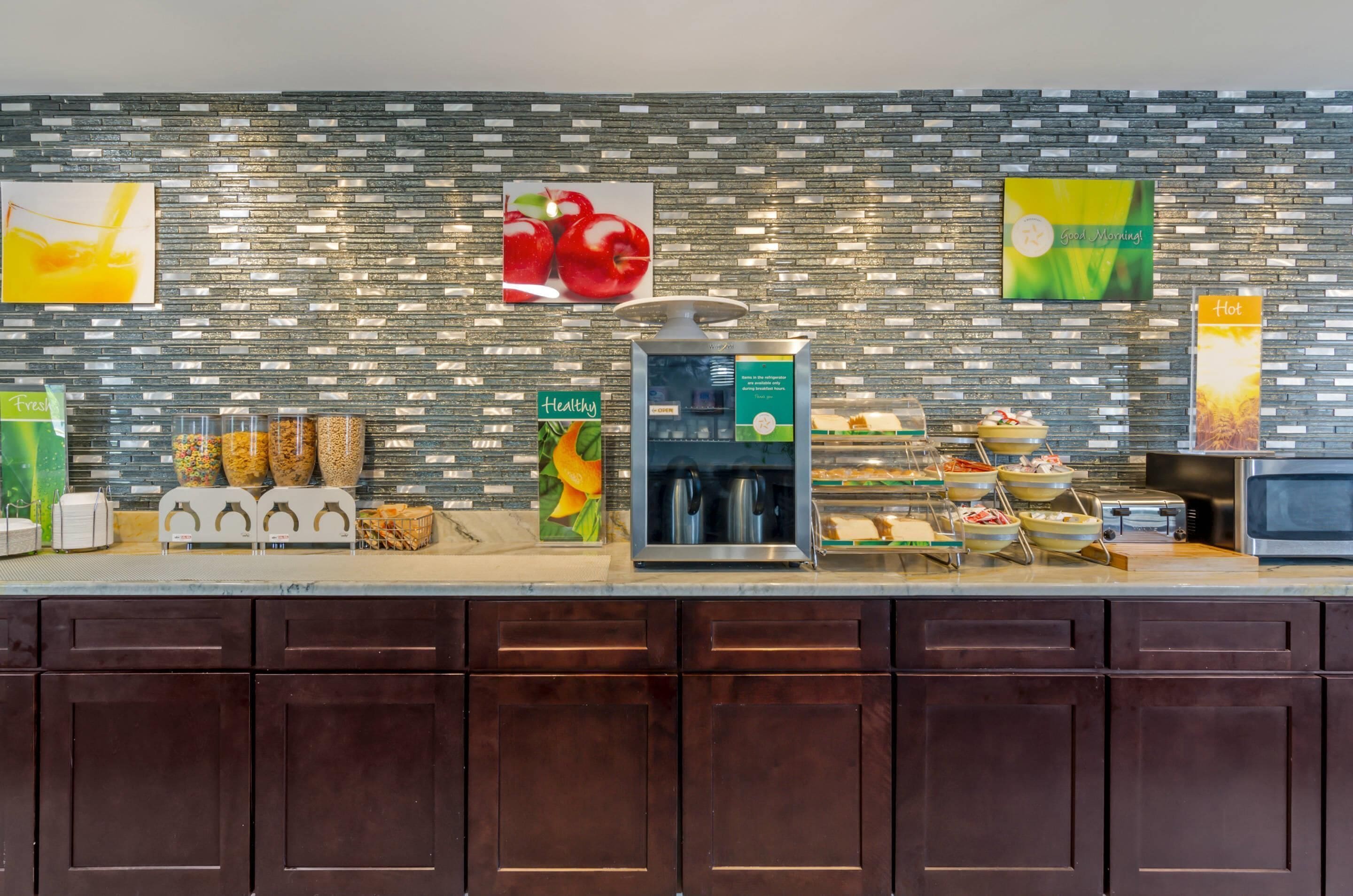 Espaço de buffet de café da manhã com diversas opções de alimentos, incluindo cereais, frutas e bebidas.