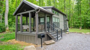 A cabin with a covered porch, a staircase, and a mailbox.