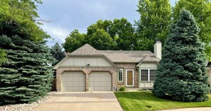 A two-story house with a garage, a chimney, and a well-maintained lawn. - Ideally located, cozy and welcoming! (Arvada)