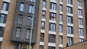 A multi-story residential building with a brick facade, balconies, and a staircase leading to the entrance. - Captivating 2-bed Apartment in Glasgow (Glasgow)
