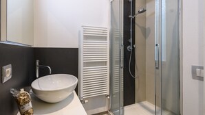 A modern bathroom with a glass-enclosed shower, a white sink, and a towel rack. - Guelfa 14 - Two Bedroom Apartment, Sleeps 4 (Firenze)