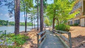 A wooden boardwalk leading to a building with a lake view.