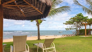 Eine Strandlounge mit Korbmöbeln und einer Struktur mit Reetdach.