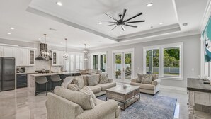 A spacious living area with a large sofa, coffee table, and a dining area with chairs.